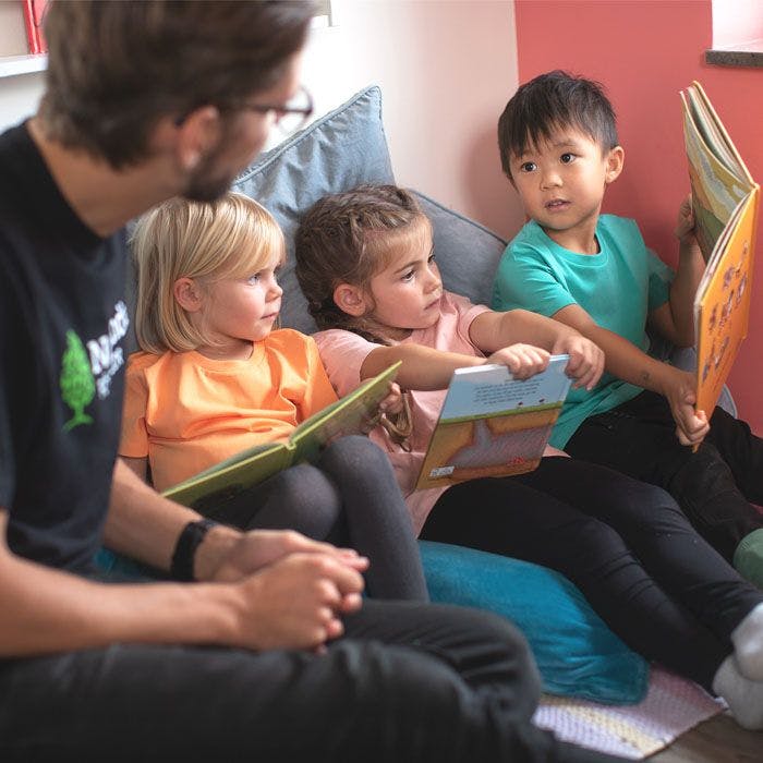 Voksen og barn leser i sofakrok